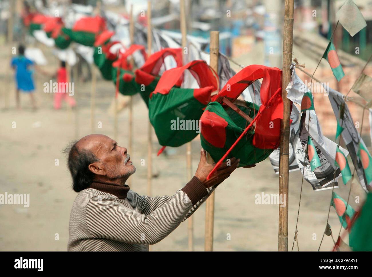 A supporter of Bangladesh's Awami League party displays replicas of