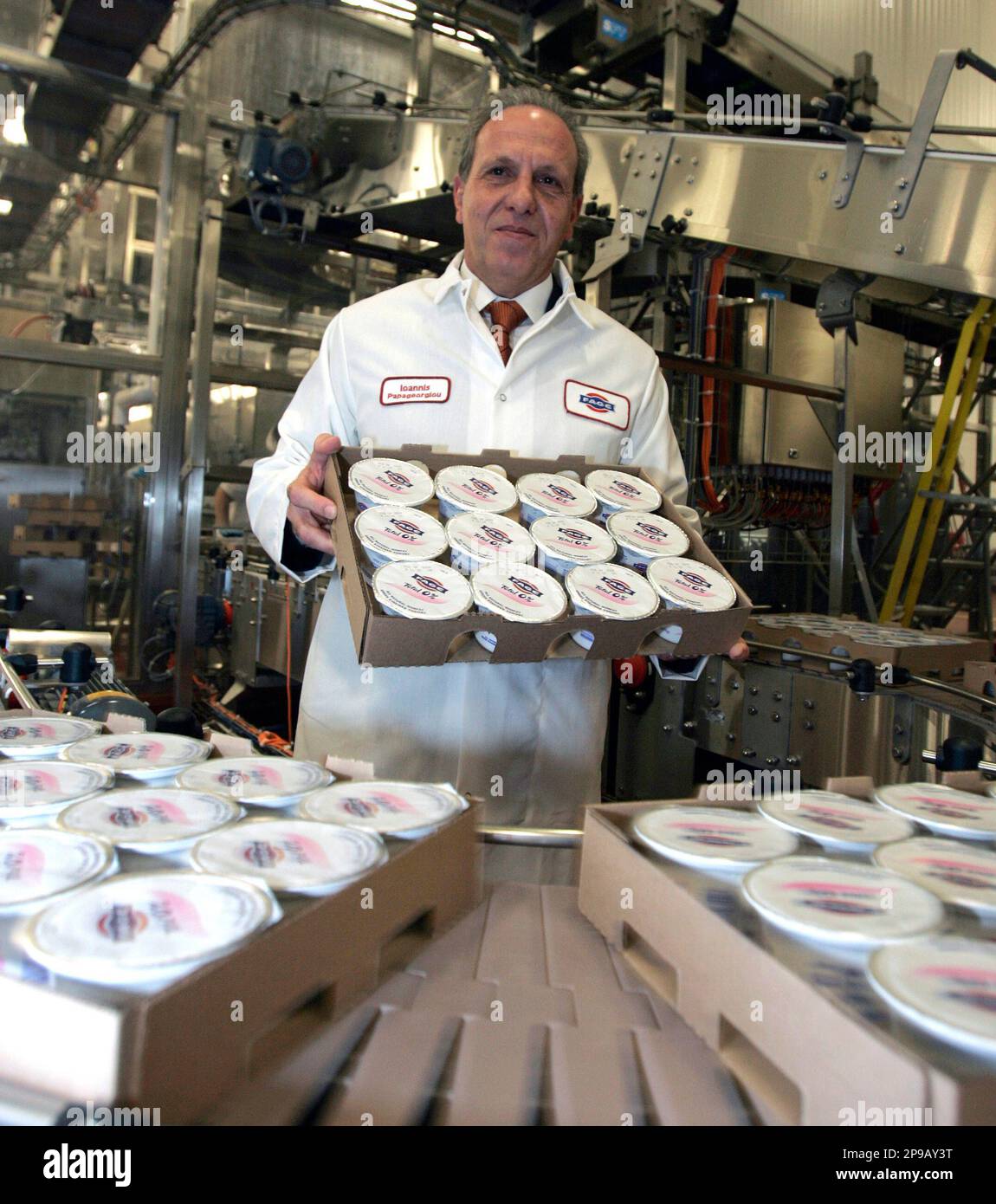 Ioannis Papageorgiou, president of Fage USA, poses with a case of yogurt on  the company's production line in Johnstown, N.Y., Wednesday, Dec. 10, 2008.  Fage, the largest dairy company in Greece, is