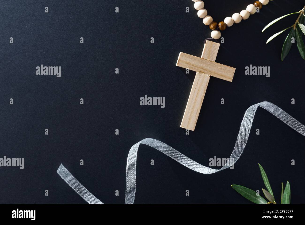 Easter religious background with three burning candles christian cross and olive branches around. Front view. Stock Photo