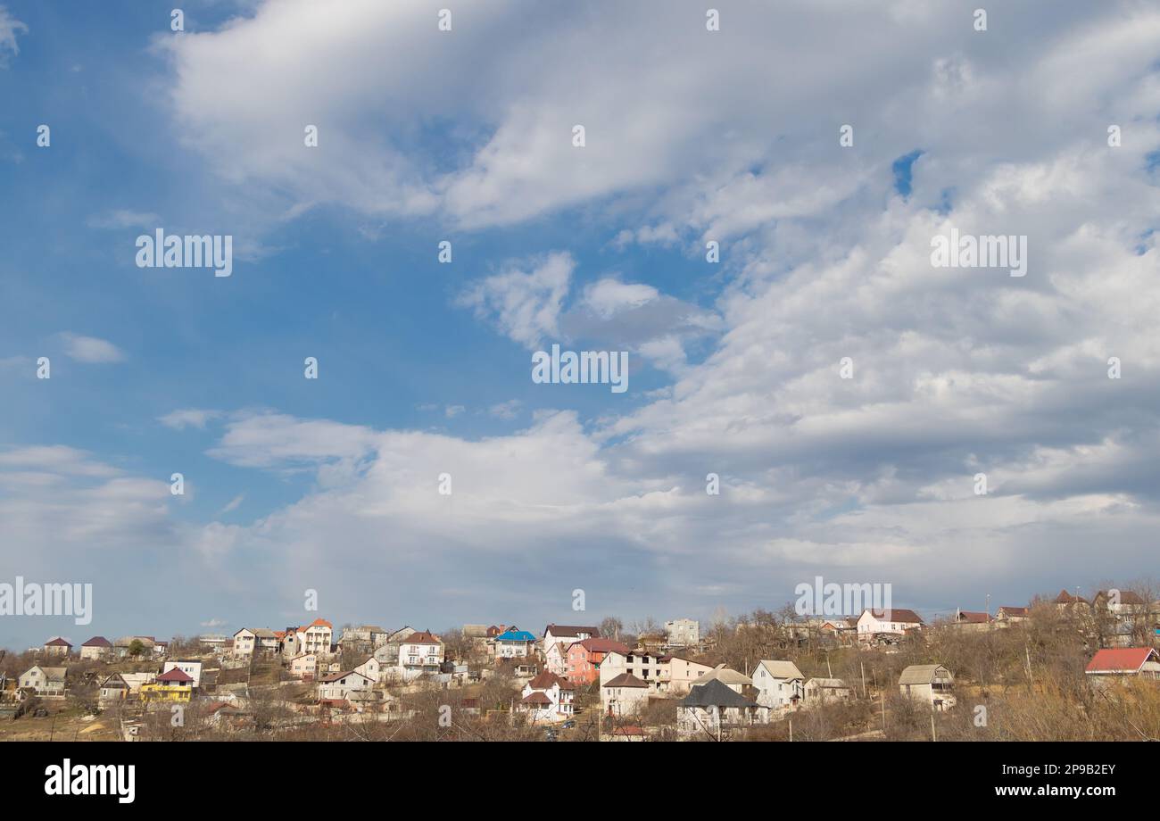 Panorama of houses on a hill against a blue sky with clouds Stock Photo ...