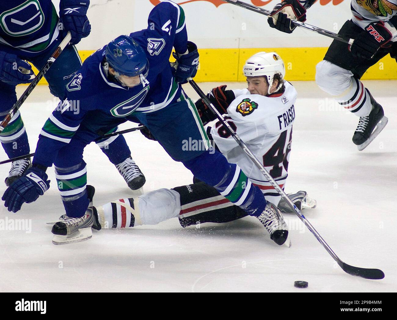 Chicago Blackhawks' Colin Fraser, right, falls to the ice while battling  Vancouver Canucks' Ryan Kesler for the puck during the third period of an NHL  hockey game in Vancouver, Saturday, Dec. 20,