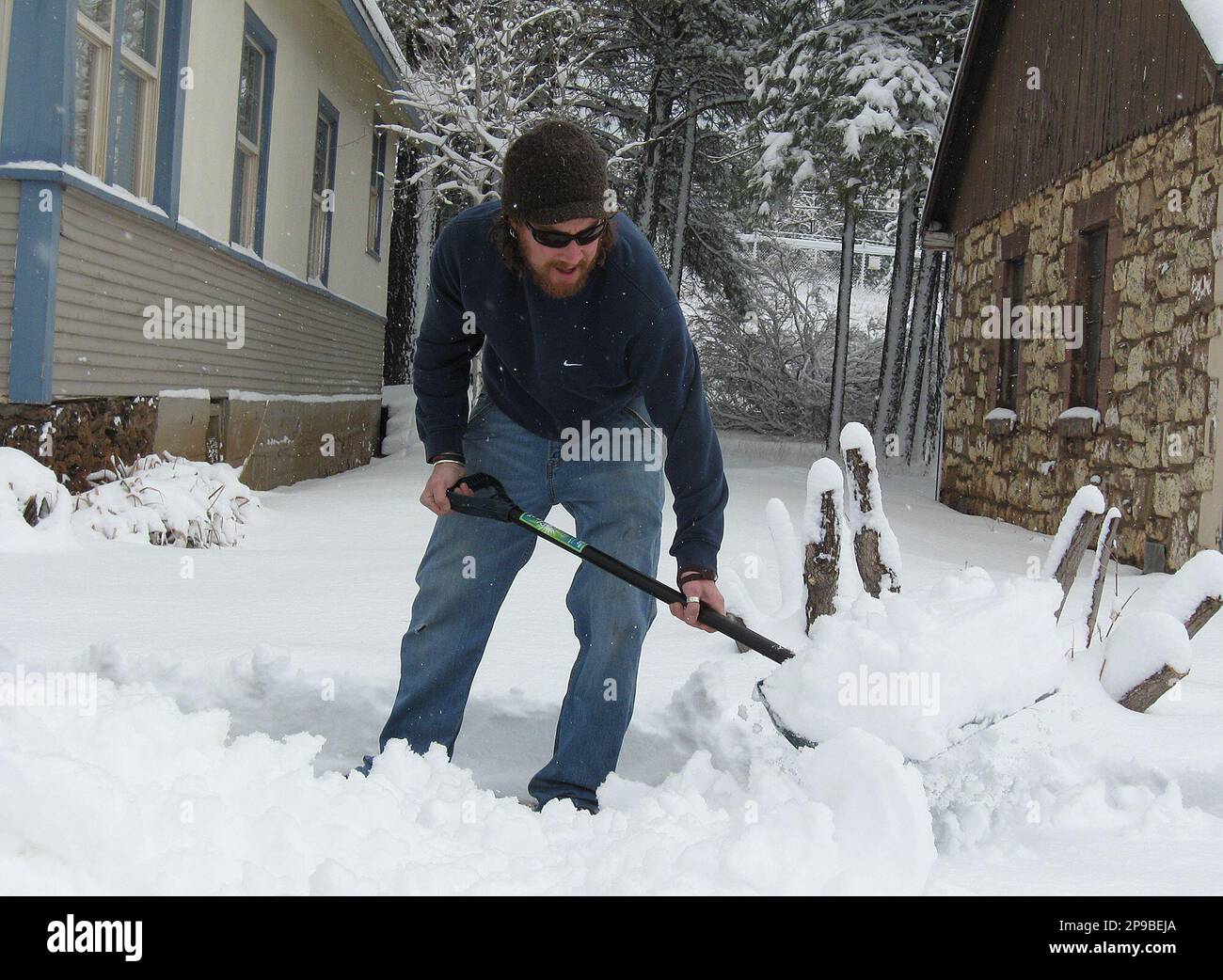 Beau Drumright, 31, shovels snow from the sidewalk Tuesday, Dec. 16