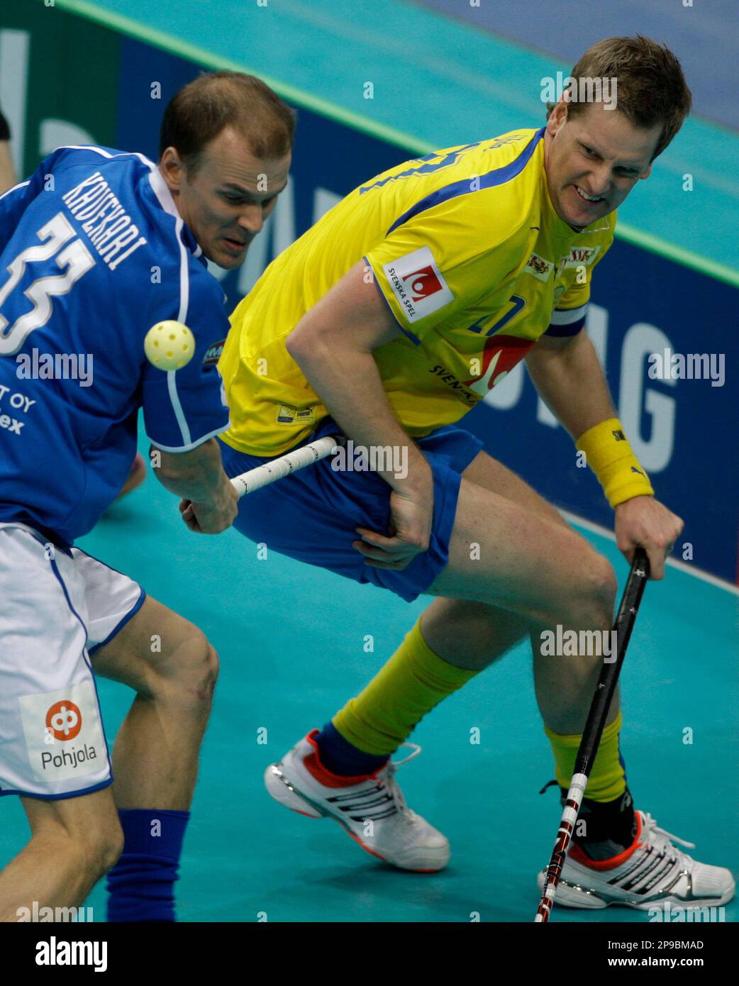 Mika Kavekari, left, from Finland fights for a ball with Niklas, Linde, right, from Sweden during their Floorball World Championship gold medal match in Prague, Czech Republic, Sunday, Dec