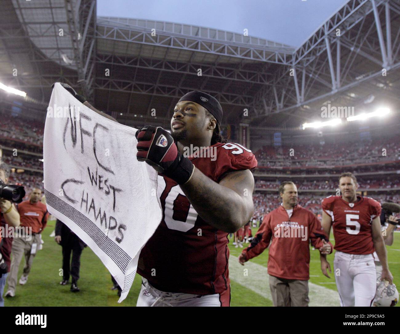 Arizona Cardinals defensive tackle Darnell Dockett waves a towel at fans as  he leaves the field after the Cardinals clinched the NFC West championship  by defeating the St. Louis Rams in an