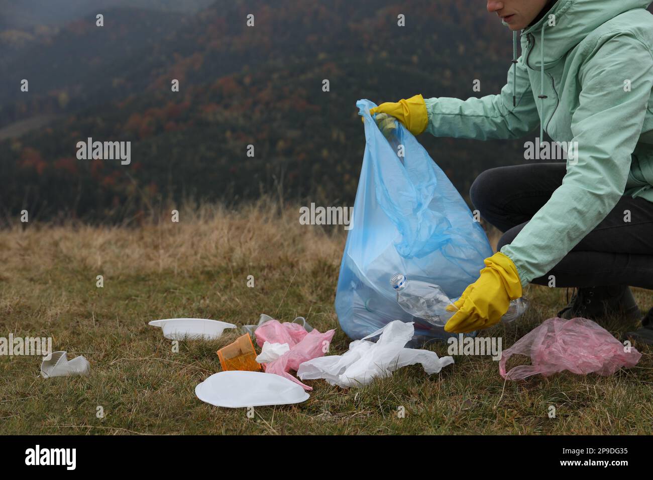 Woman with trash bag collecting garbage in nature, closeup. Space for ...