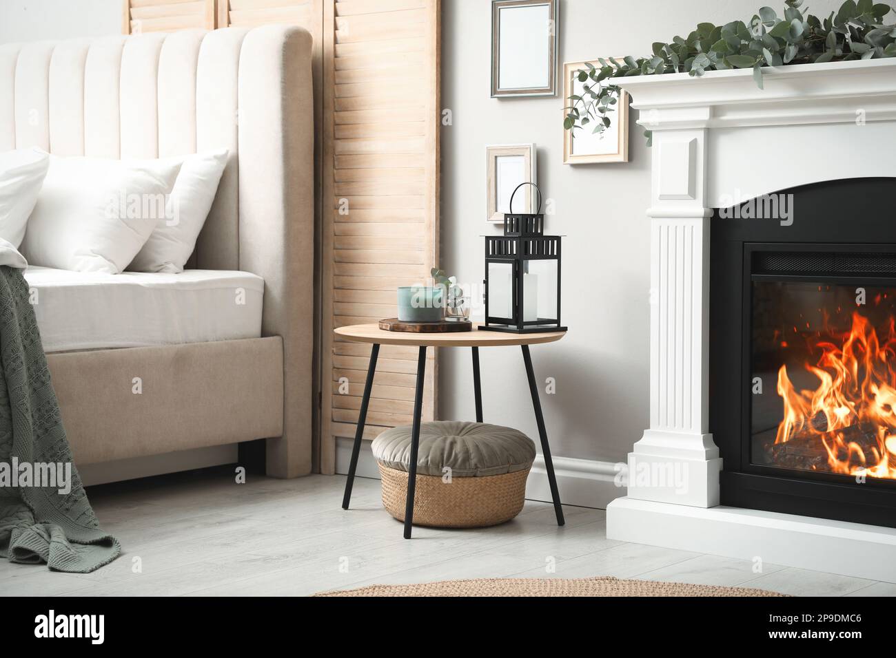 Beautiful eucalyptus garland on fireplace and wooden table in stylish