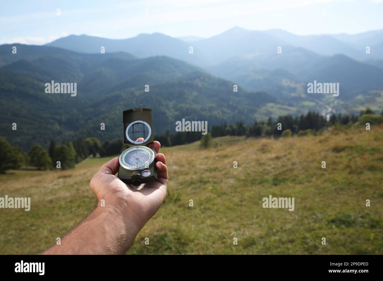 Man using compass during journey in mountains, closeup Stock Photo