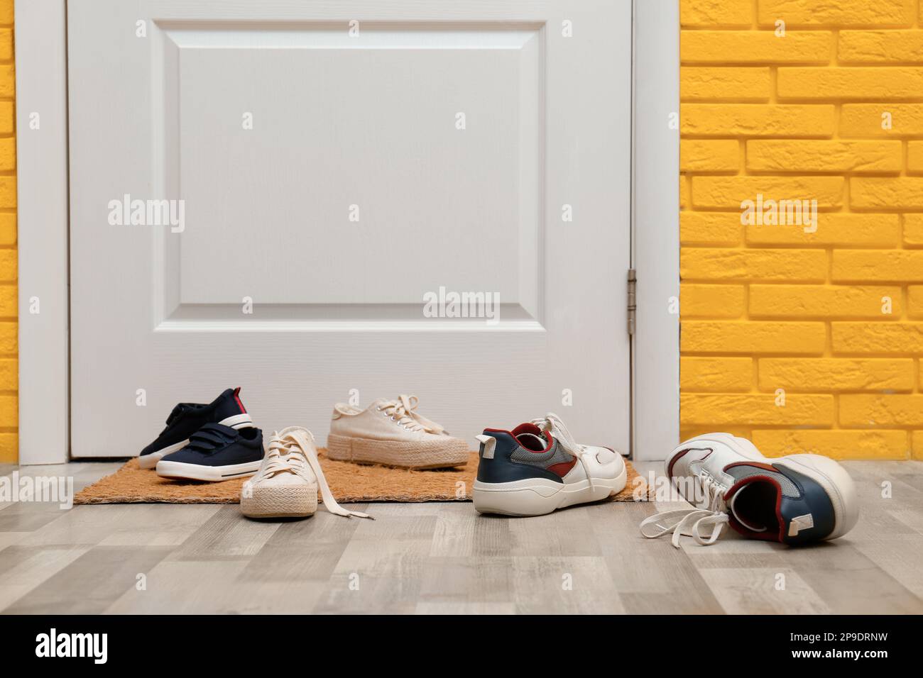 Stylish shoes and mat near door in hallway Stock Photo Alamy