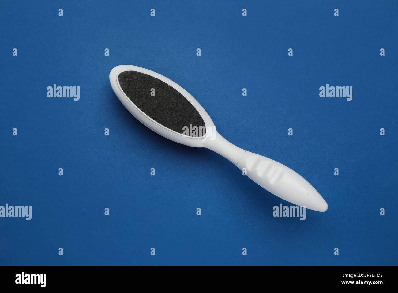 White foot file on blue background, top view. Pedicure tool Stock Photo