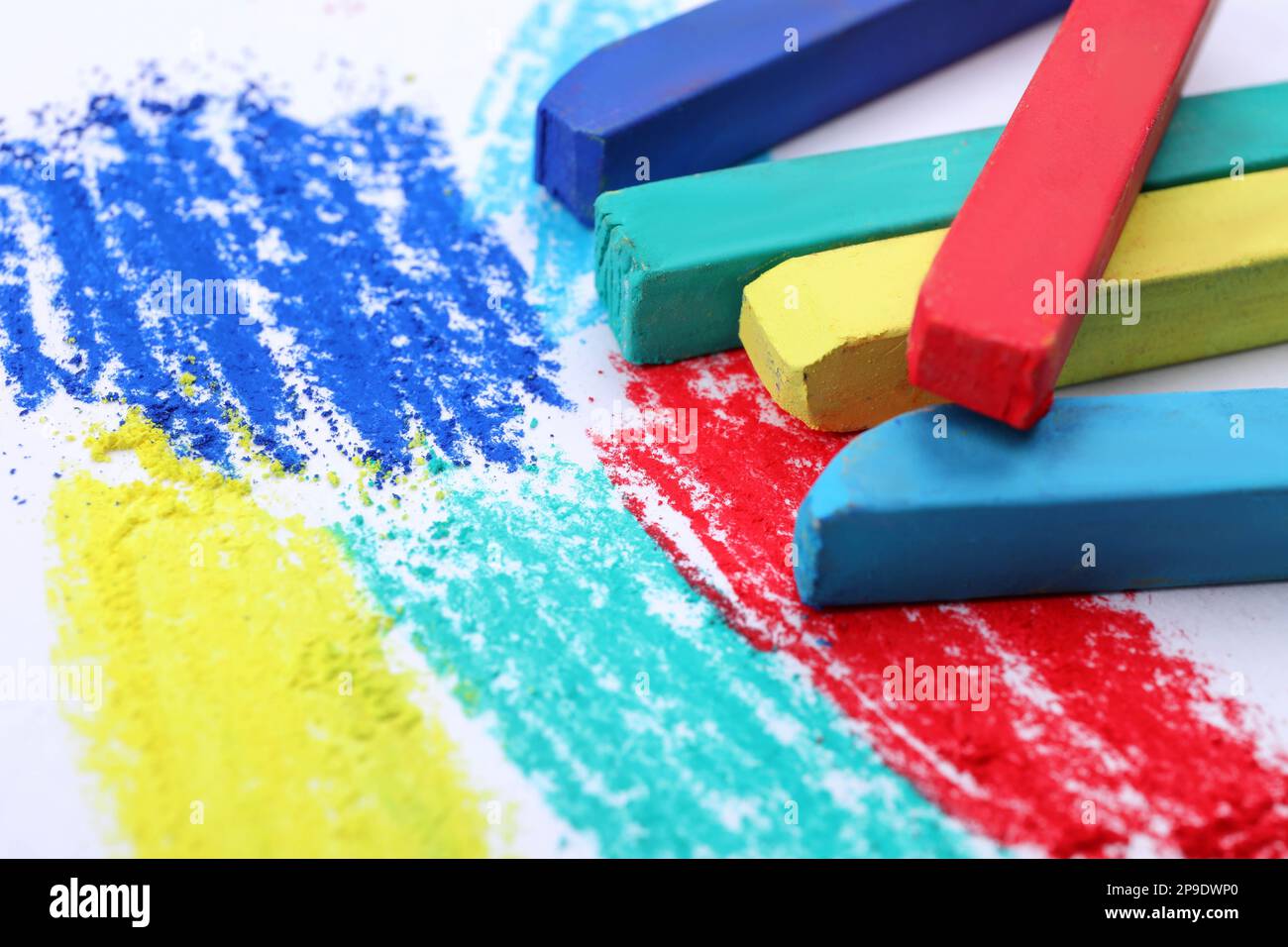 Colorful pastel chalks on white background, closeup. Drawing materials