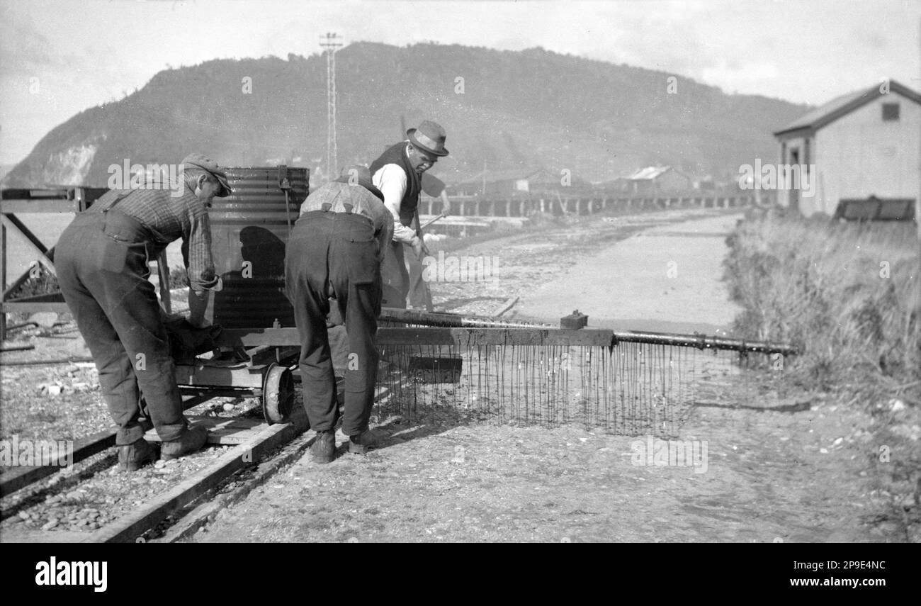 Men applying tar seal to a road in Greymouth, 1930s, Westland, New Zealand Stock Photo