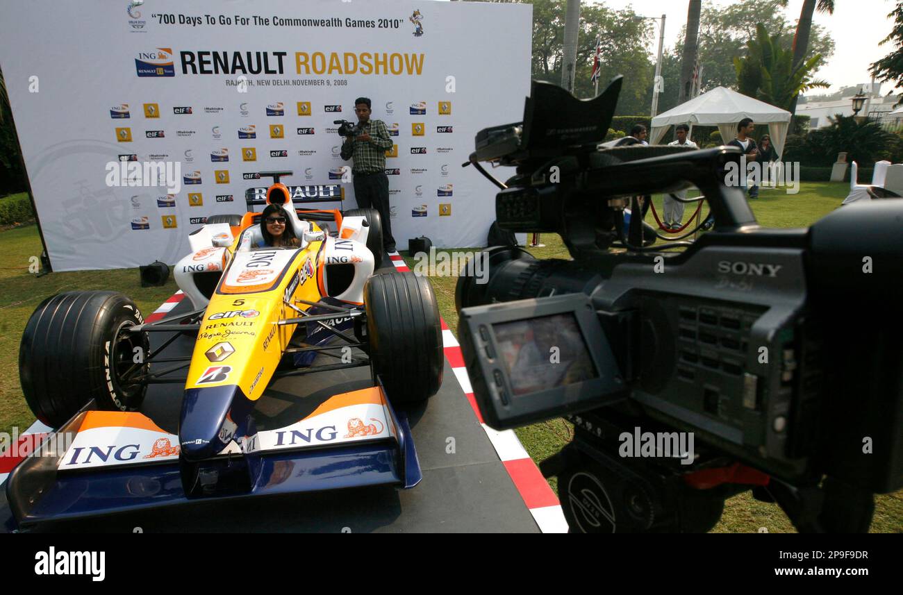 A television journalist reports while sitting in a Renault F1 racing car at  a press conference to mark 700 days count down for the 2010 Commonwealth  Games in New Delhi, India, Thursday,