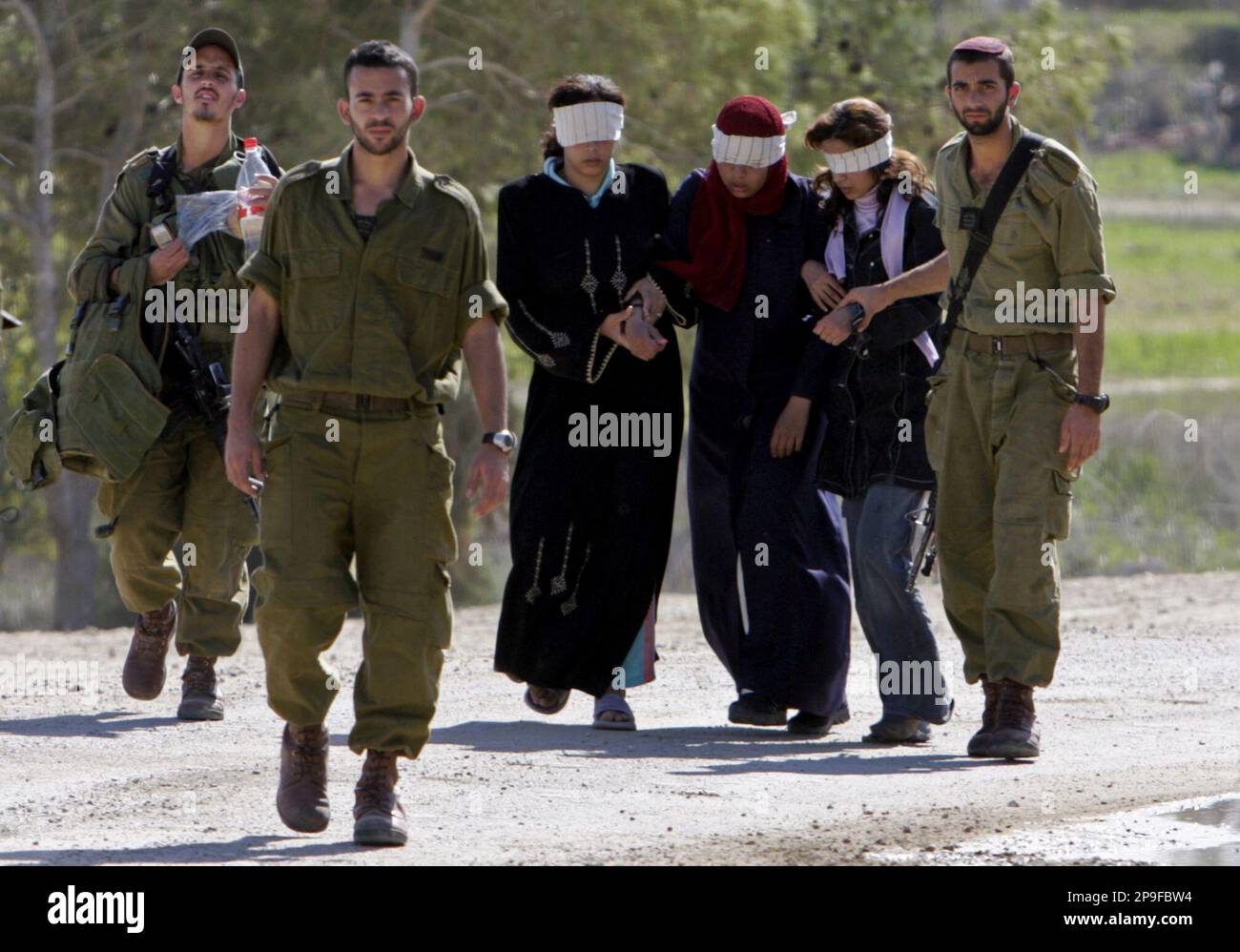 Israeli soldiers escort blindfolded Palestinian women to the Kissufim Israeli  army base,after they were detained during a military operation in the Gaza  Strip, Wednesday, Nov. 5, 2008. Israel and Gaza's Hamas rulers, image size:1300x998