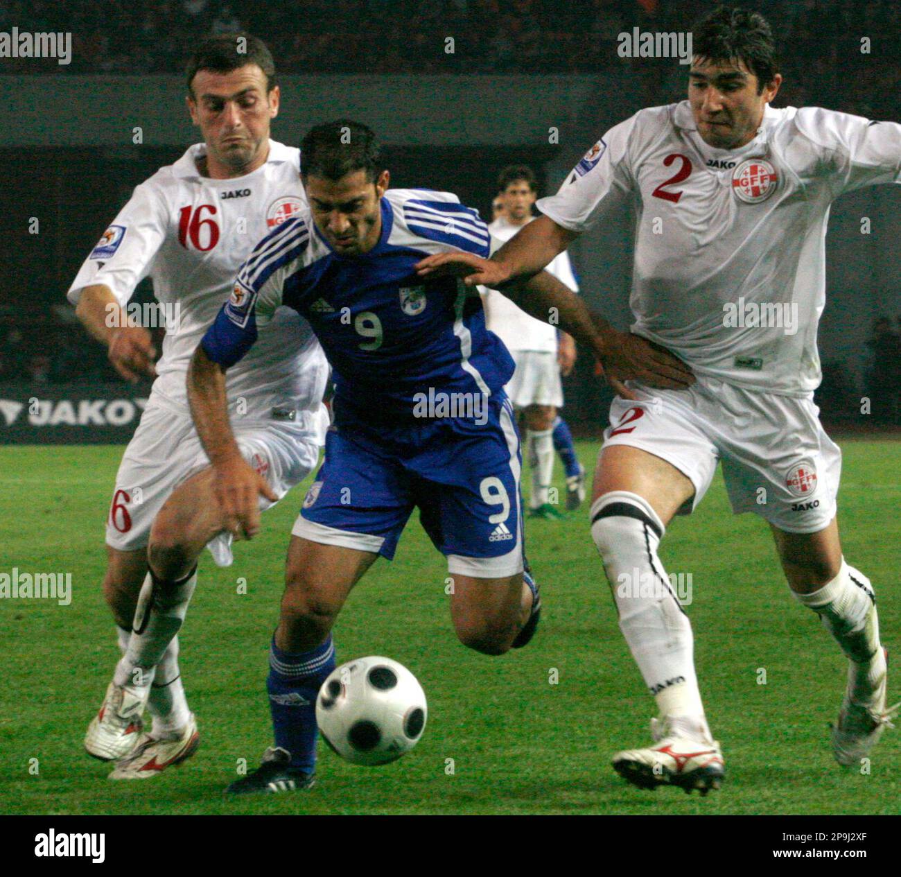 Cyprus' Ioannis Okkas, center, fights for the ball with Georgia's Luka  Razmadze, left, and Ucha Lobjanidze during their World Cup group 8  qualifying soccer match between Georgia and Cyprus in Tbilisi, Georgia,