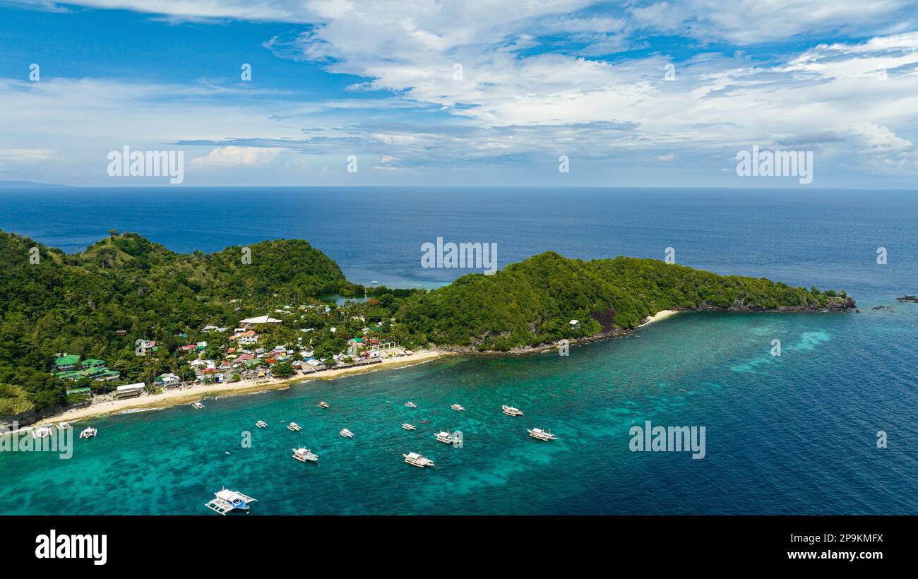 Tropical island with a beach. Apo Island. Popular dive site and snorkeling destination with tourists. Negros, Philippines. Stock Photo