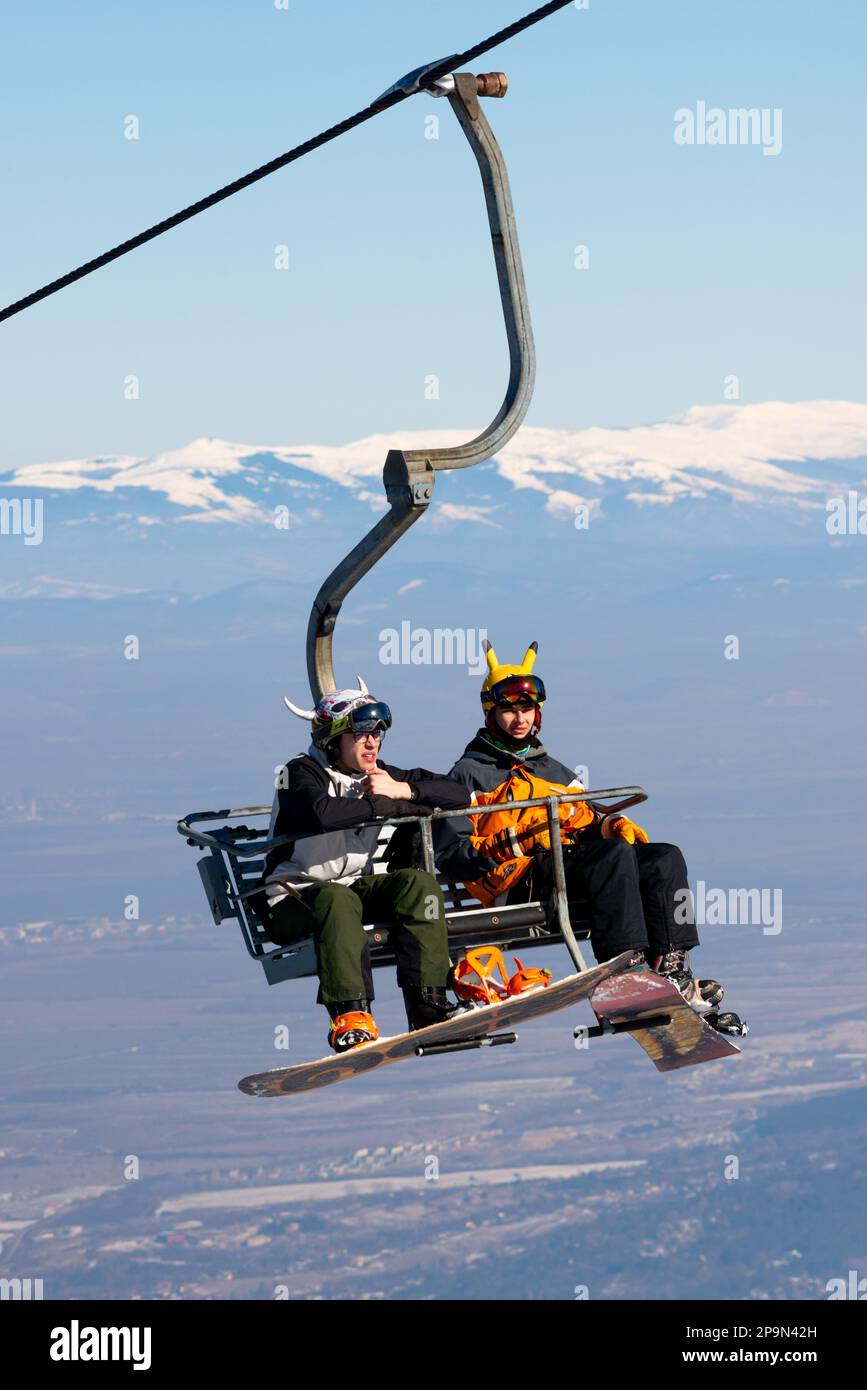 Snowboarders on chairlift in Vitosha Mountain above Sofia, Bulgaria, Eastern Europe, Balkans, EU Stock Photo