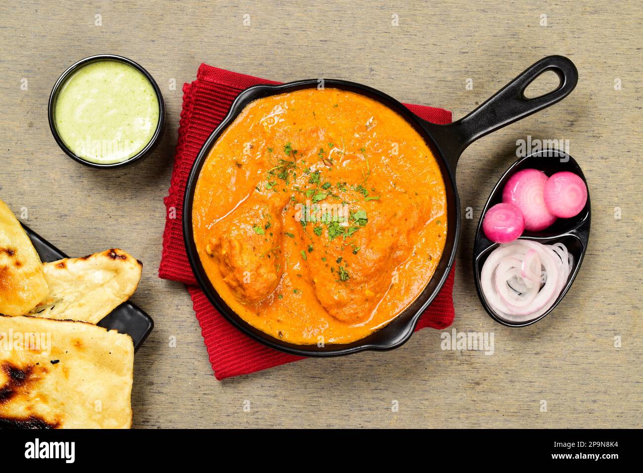 Top view of butter chicken served with naan and mint chutney Stock