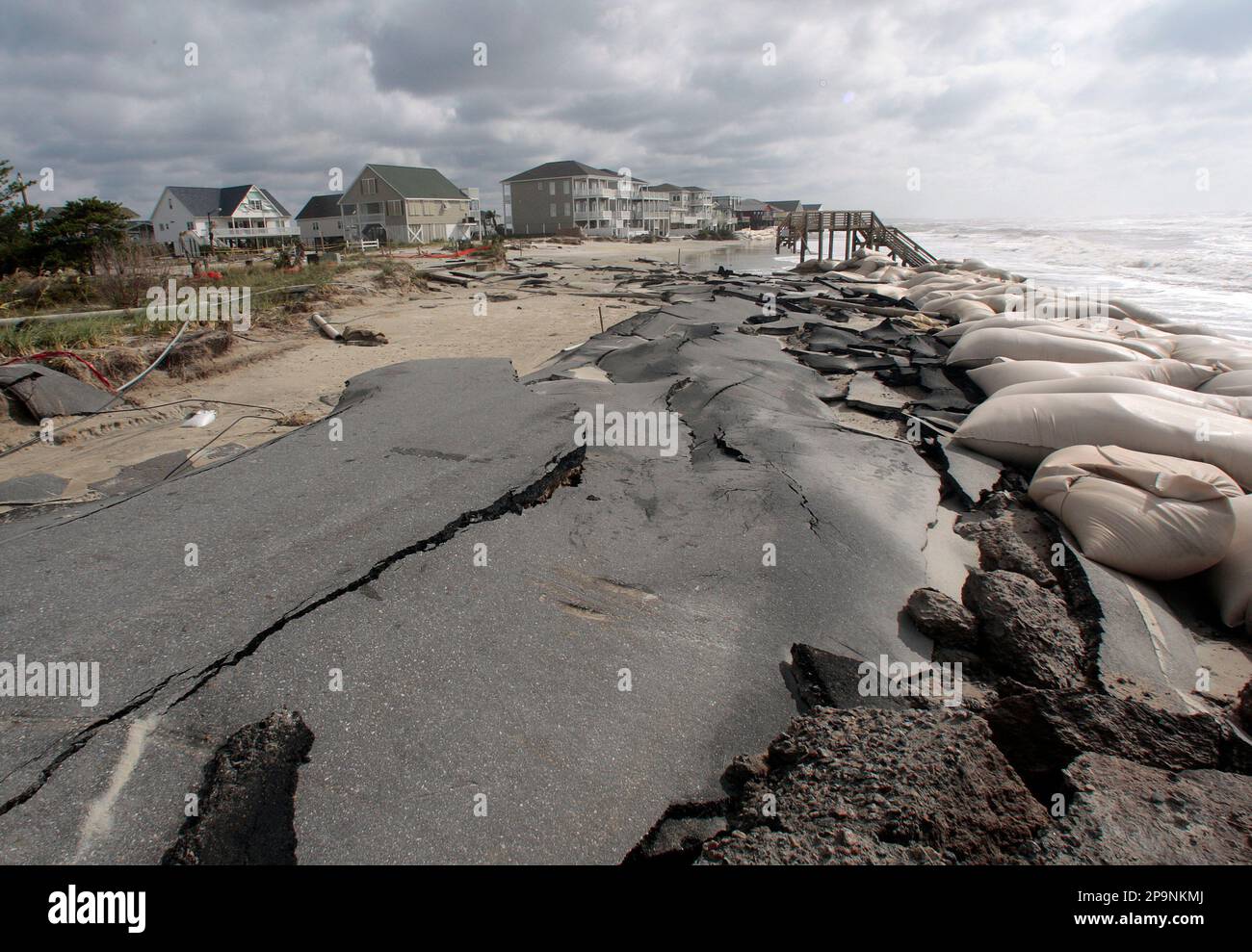 Sandbags line an eroded beach road washed away by wind and waves from Tropical Storm Hanna in