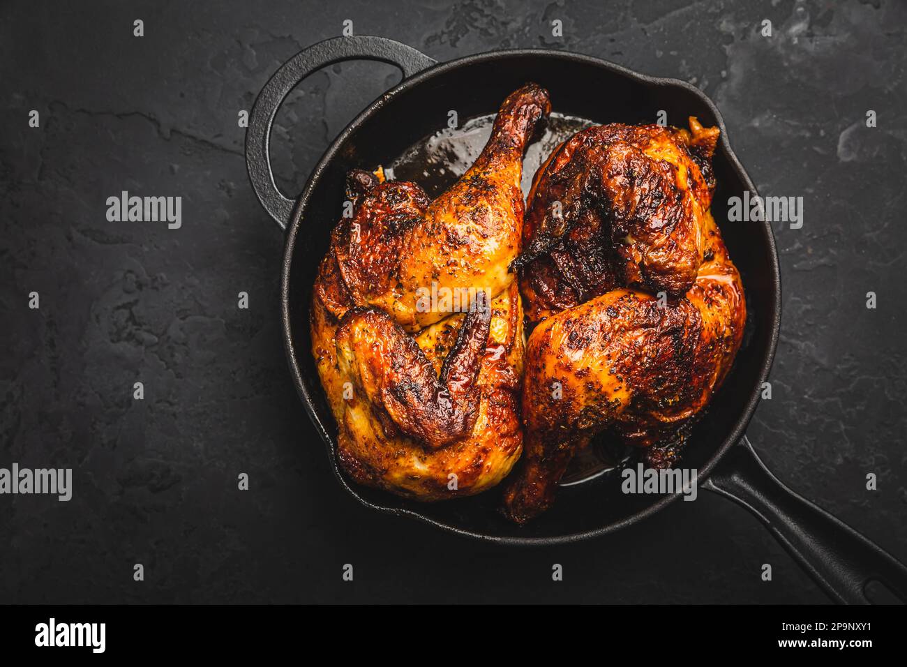 Roasted half chicken in pan on black background Stock Photo Alamy