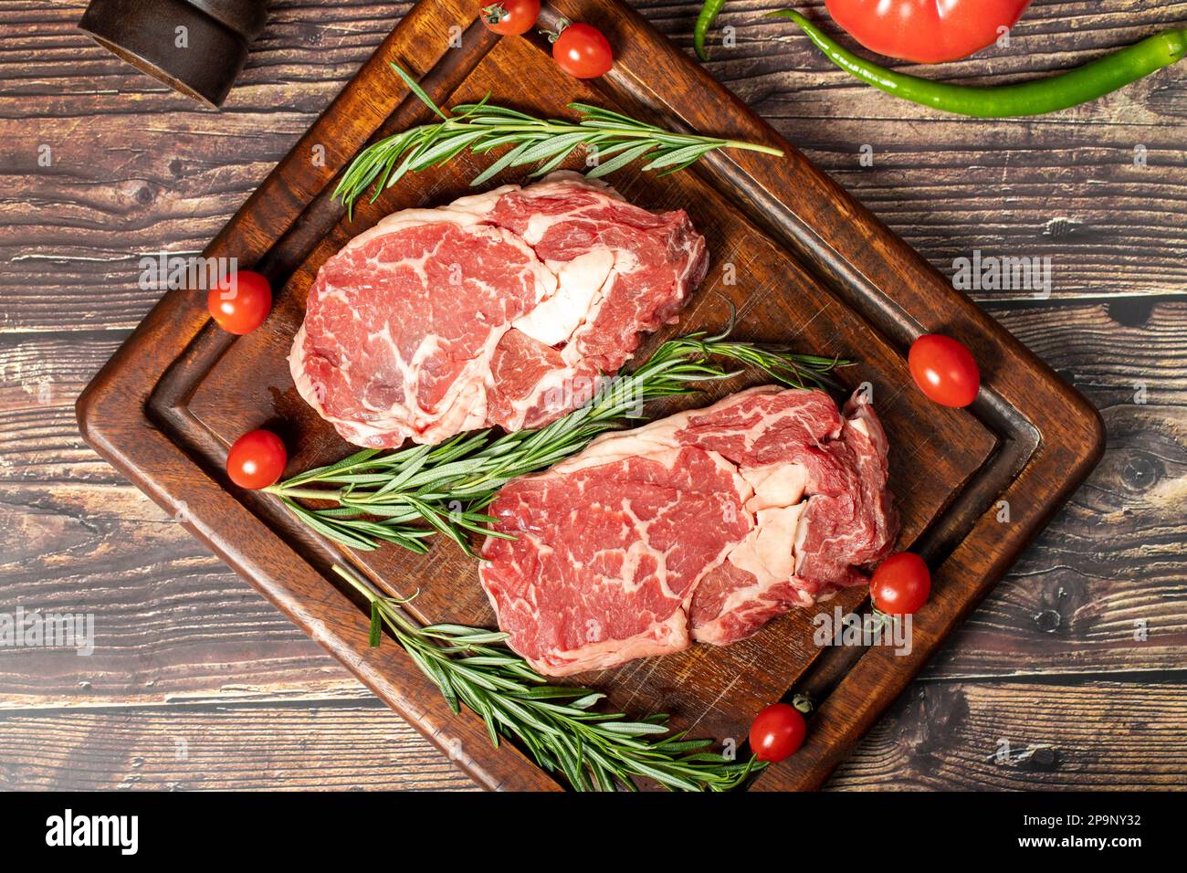 Beef ribeye. Two fresh raw ribeye steaks with spices and rosemary ...