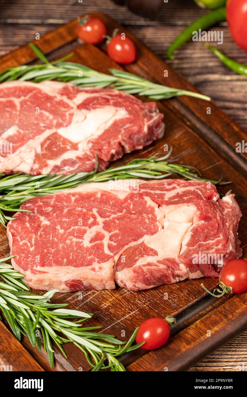 Beef ribeye. Two fresh raw ribeye steaks with spices and rosemary. Special entrecote. wood