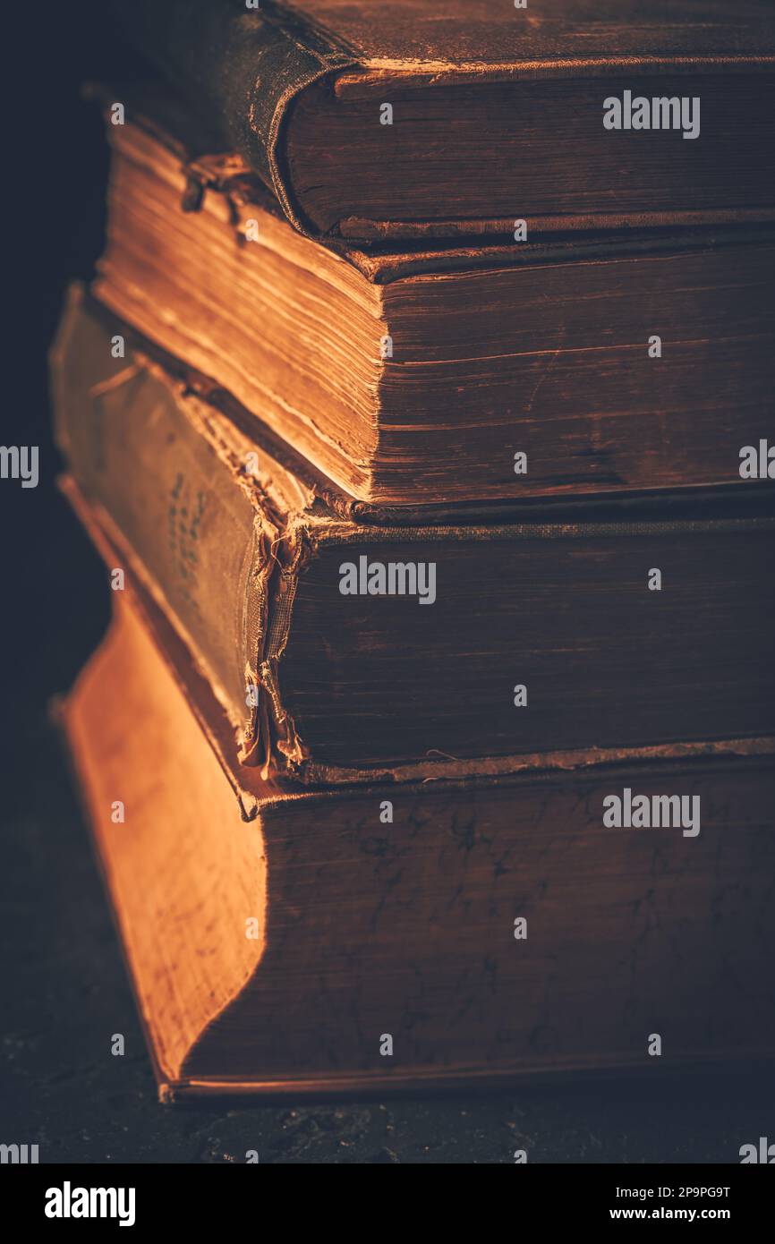 Vintage books stack on old wooden surface, selective focus Stock Photo