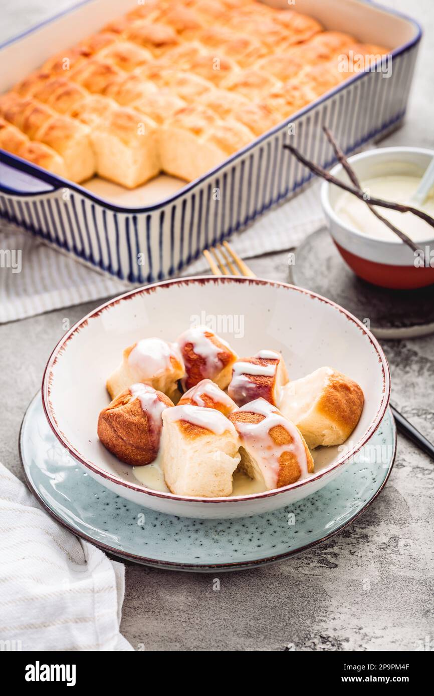 Buchteln, sweet rolls made of yeast dough with milk and butter, served with vanilla sauce. Traditional meatless dish in Europe Stock Photo