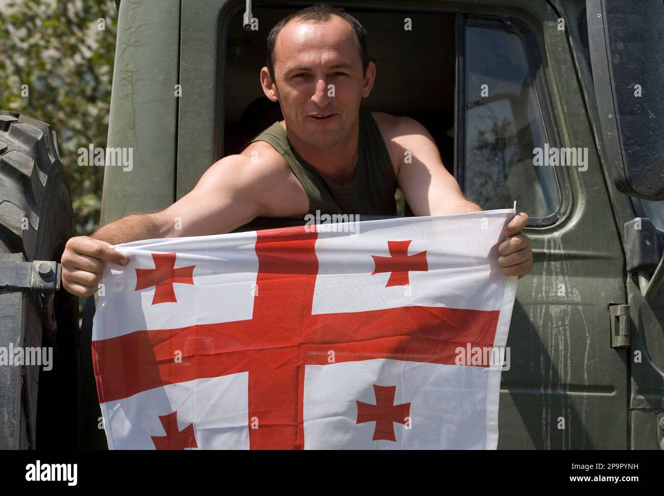 A Russian soldier in a military vehicle, shows his trophy, a