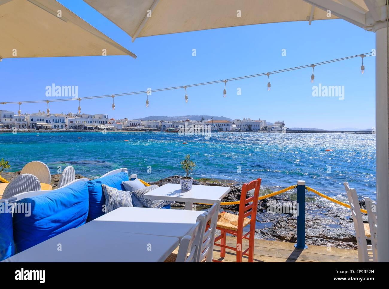 Skyline of the Mykonos town in Greece: view of the harbor from a typical restaurant on the seashore. Stock Photo