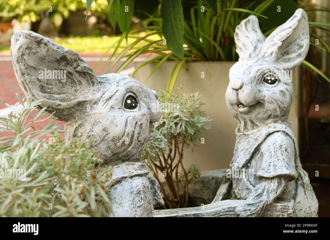 Pair of Adorable Easter Bunny Sculptures at the Yard Stock Photo