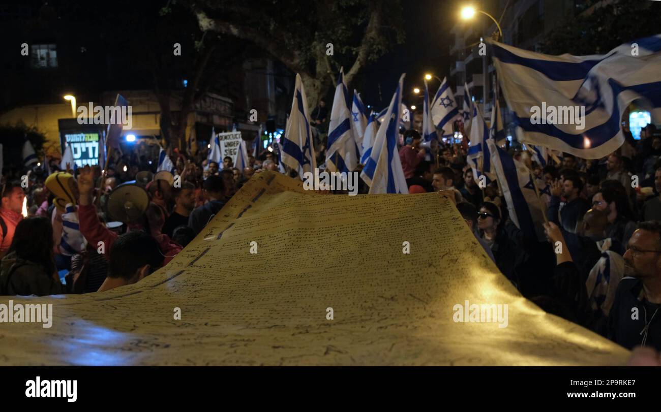 TEL AVIV, ISRAEL - MARCH 9: Anti-Government protesters carry a large copy of Israel's Declaration of Independence and hold Israeli flags during a demonstration against Israel's hard-right government judicial system plan that aims to weaken the country's Supreme Court on March 9, 2023 in Tel Aviv, Israel. Stock Photo