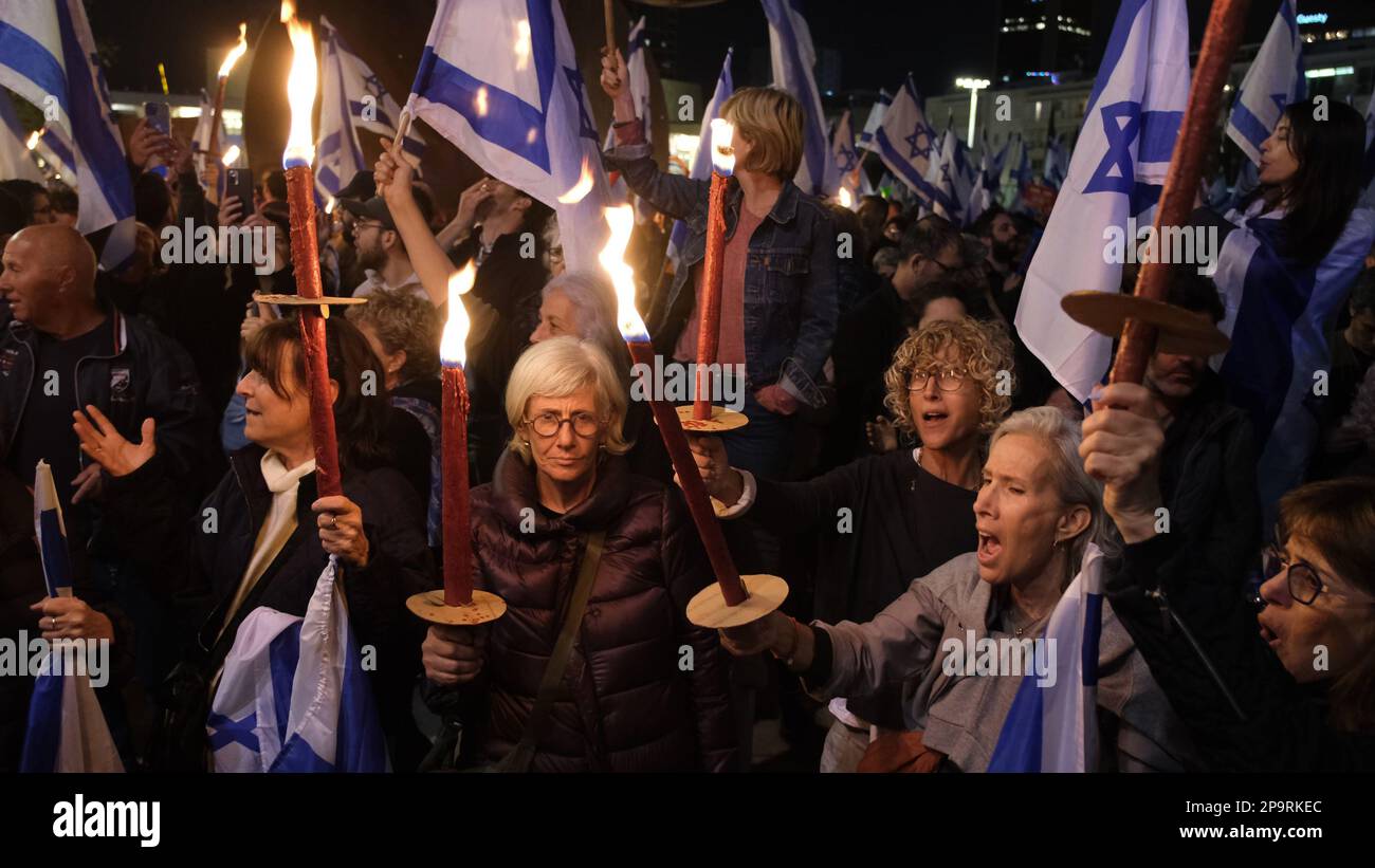 TEL AVIV, ISRAEL - MARCH 9: Anti-Government protesters hold flaming torches during a mass demonstration against Israel's hard-right government judicial system plan that aims to weaken the country's Supreme Court on March 9, 2023 in Tel Aviv, Israel. Stock Photo