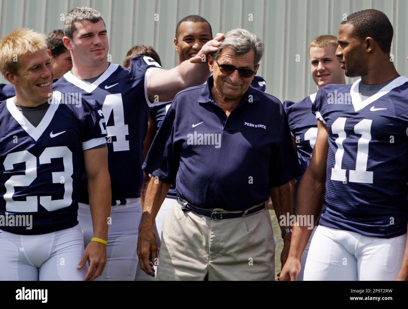 Penn State guard Rich Ohrnberger, second from left, reaches out and fixes  coach Joe Paterno's hair during team photos in State College, Friday, Aug.  8, 2008. Left is kicker Kevin Kelly (23)
