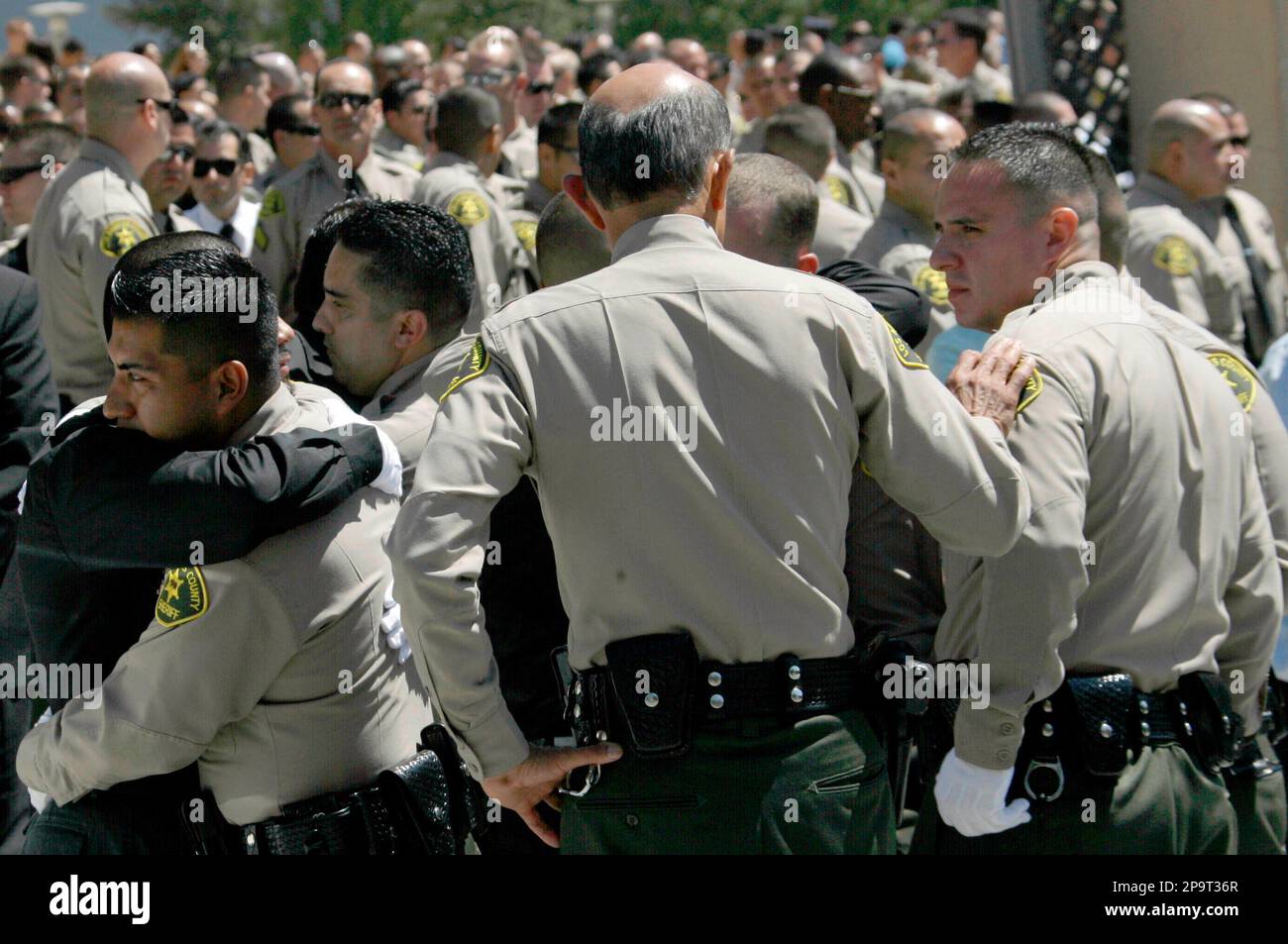 Los Angeles County Sheriff Lee Baca, center, touches the arm of an