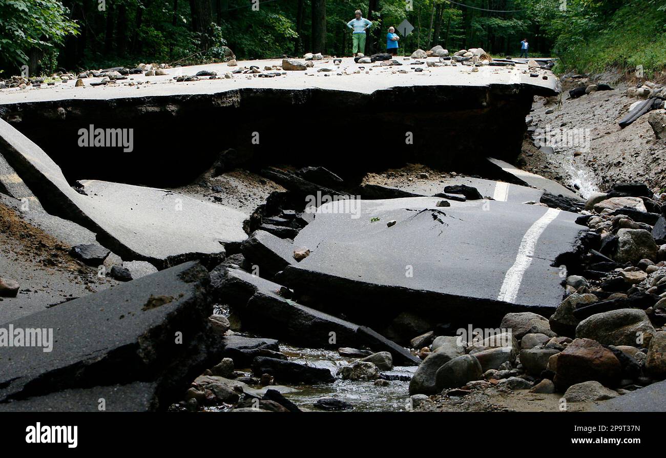 People survey the damage caused by flash floods on Winona Road in New ...