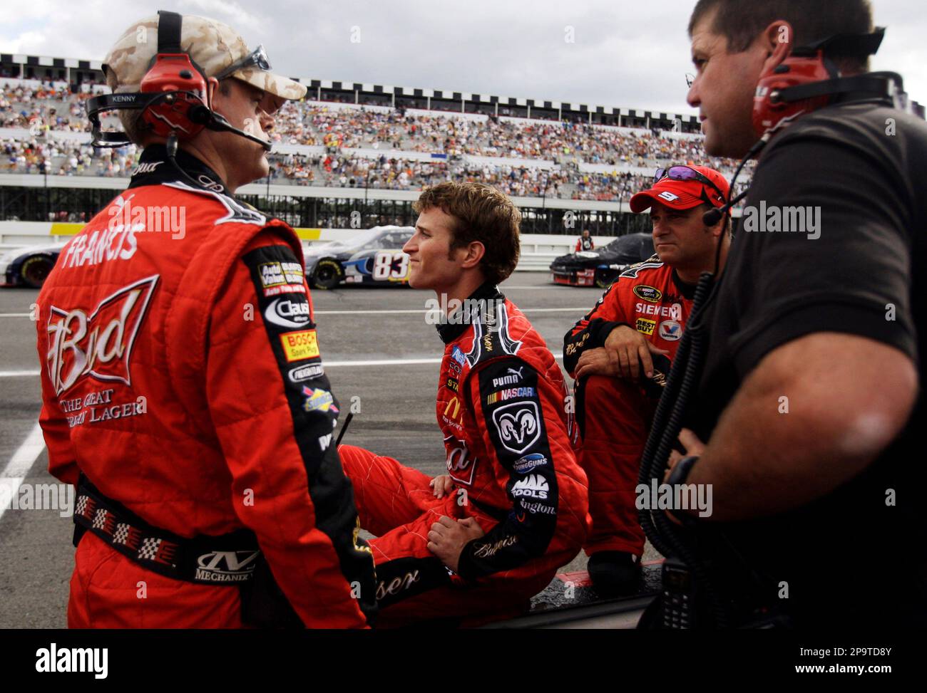 NASCAR driver Kasey Kahne and his crew sit on the wall of their pit during a red flag because of rain during the NASCAR Sprint Cup Series Pennsylvania 500 auto race at