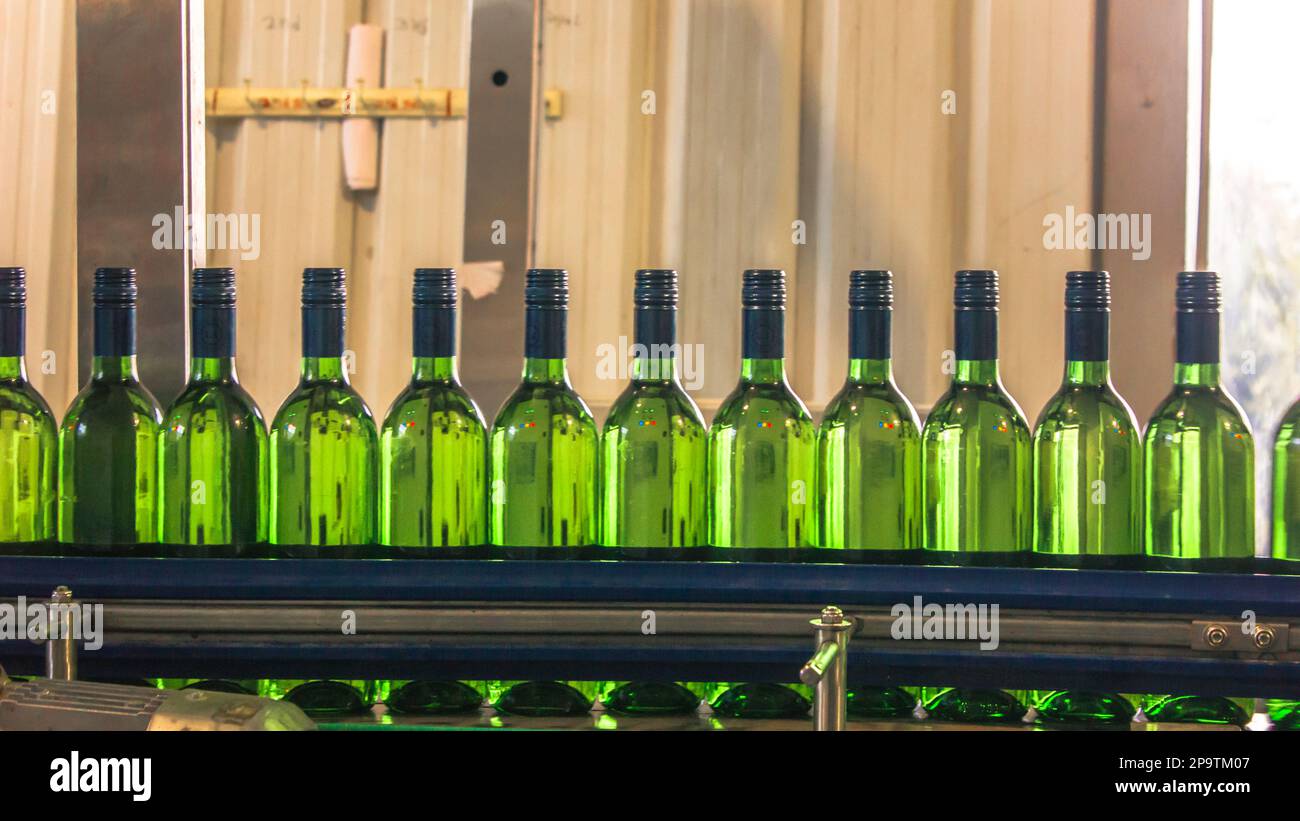 Wine bottling line - automatic plant at winery stock photo. Bottle factory, stack / pile of bottles Stock Photo