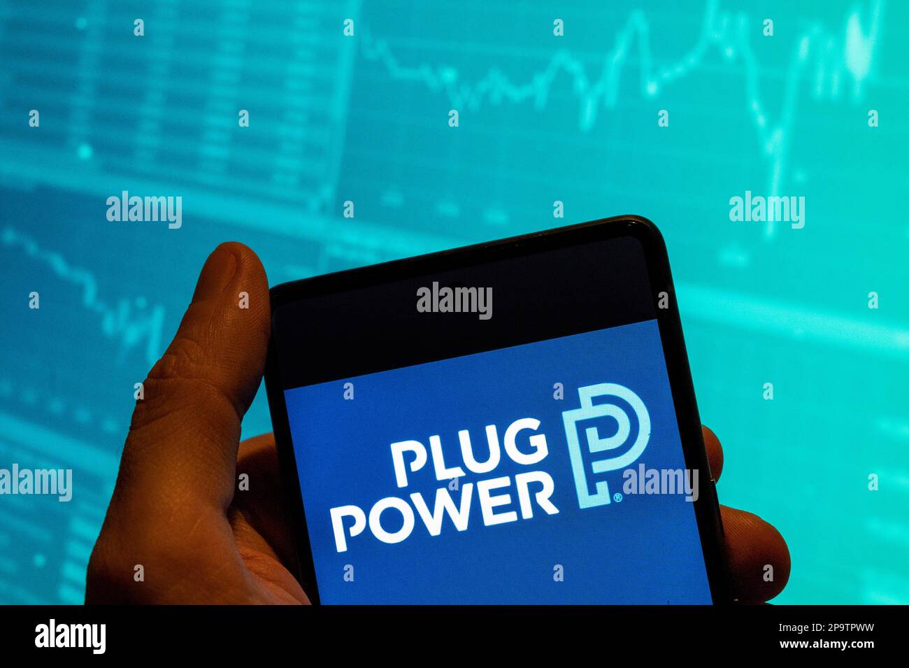 In this photo illustration, the American company engaged in the development of hydrogen fuel cell systems that replace conventional batteries in equipment, Power Plug logo is seen displayed on a smartphone with an economic stock exchange index graph in the background. Stock Photo