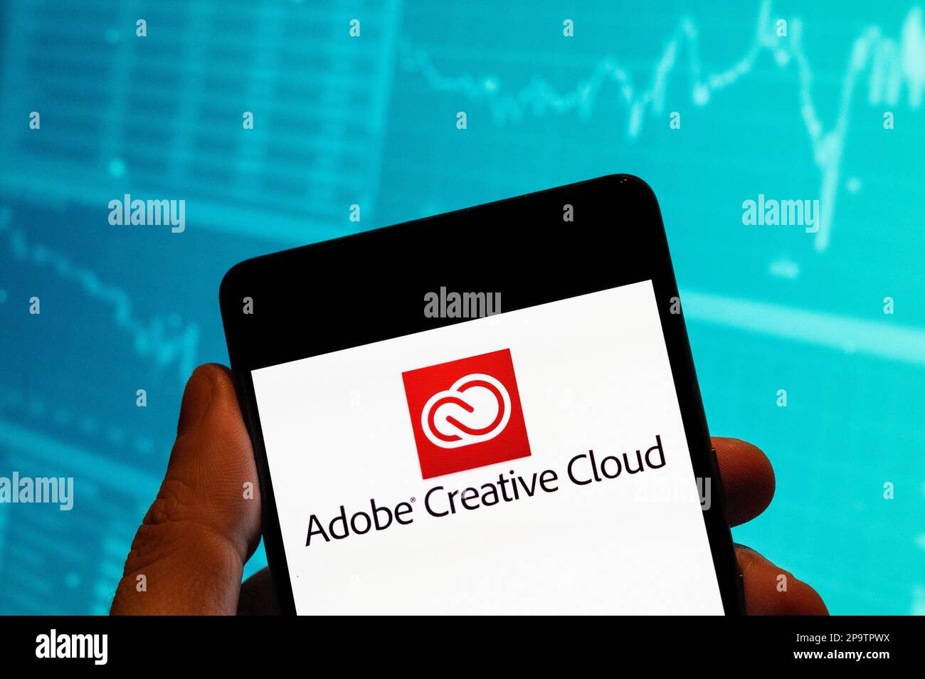 In this photo illustration, the file hosting service and computer software access owned by Adobe Systems, Adobe Creative Cloud, logo is seen displayed on a smartphone with an economic stock exchange index graph in the background. Stock Photo