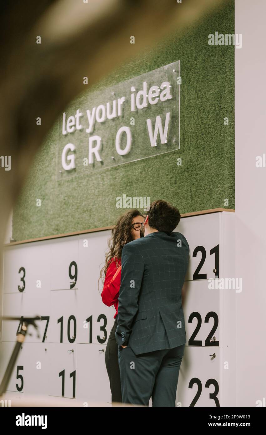 Couple kissing each other while taking a break from work at the office Stock Photo Alamy