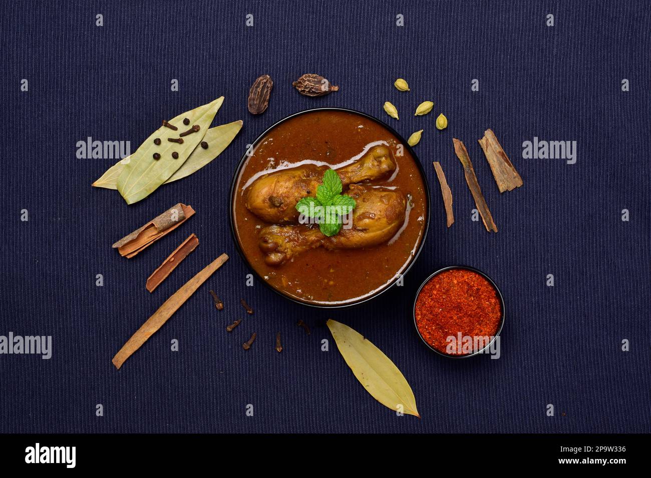 Indian style spicy chicken curry with whole spices, top view Stock