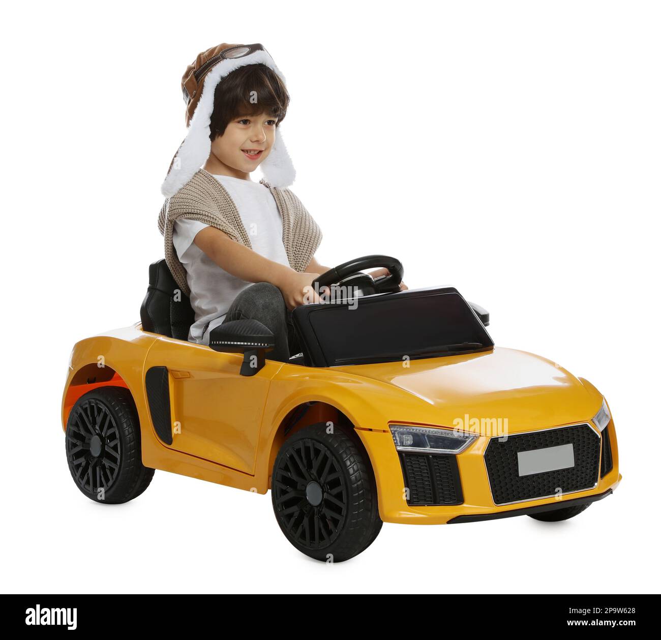 Cute little boy in pilot hat driving children's electric toy car on