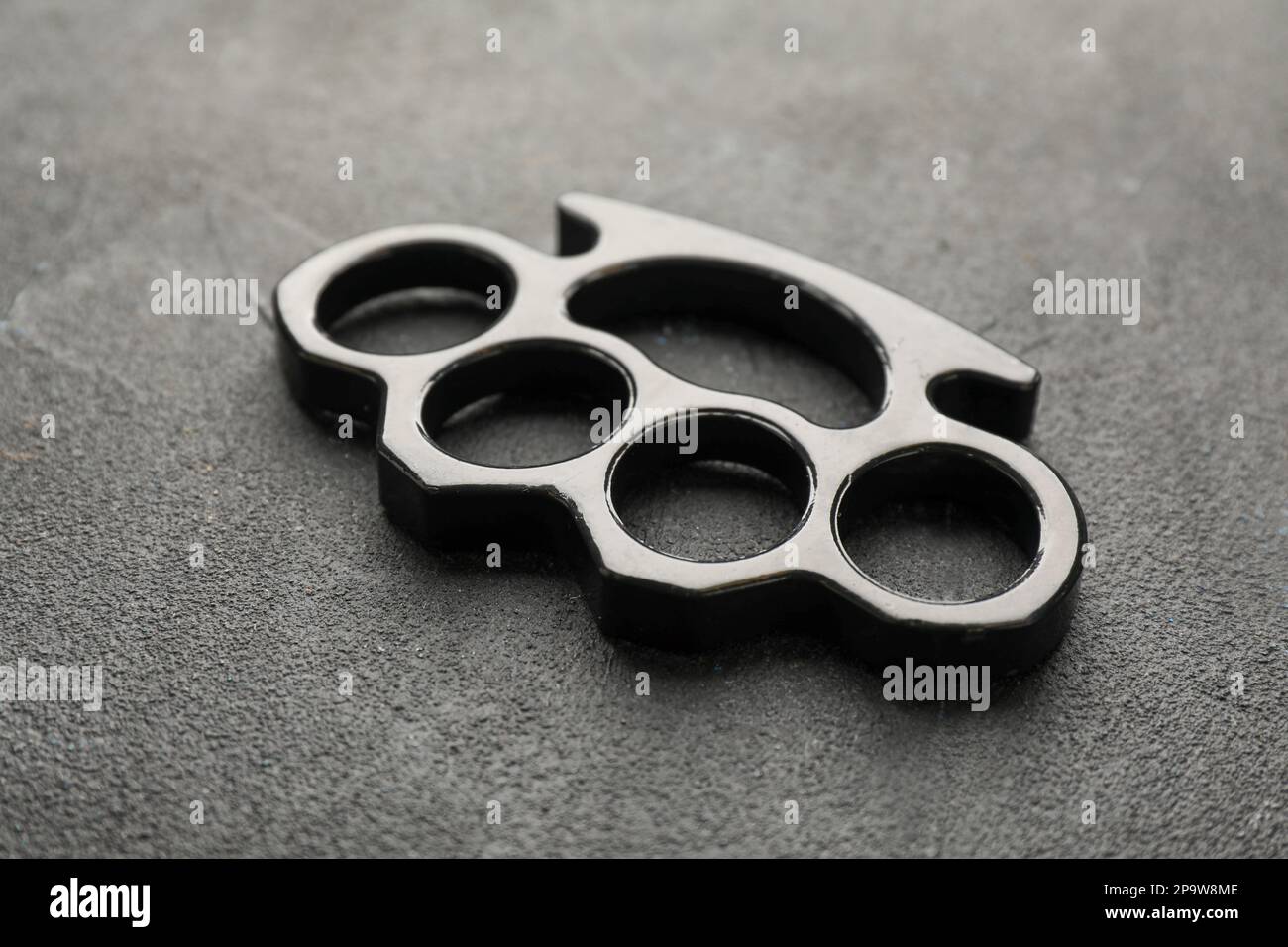 Brass knuckles on black stone background, closeup Stock Photo - Alamy