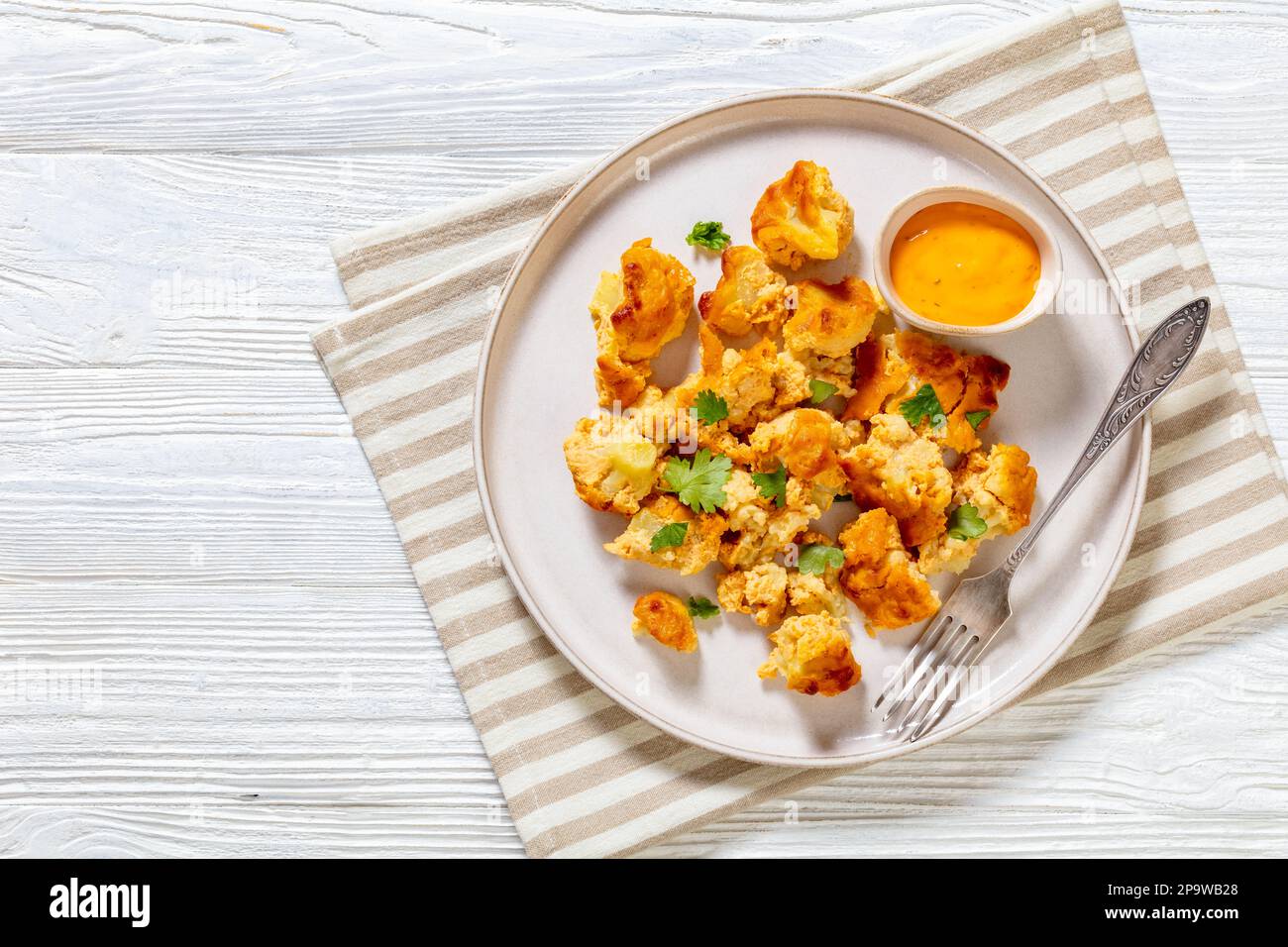 baked Cauliflower florets with paprika mayo sauce on plate with fork on