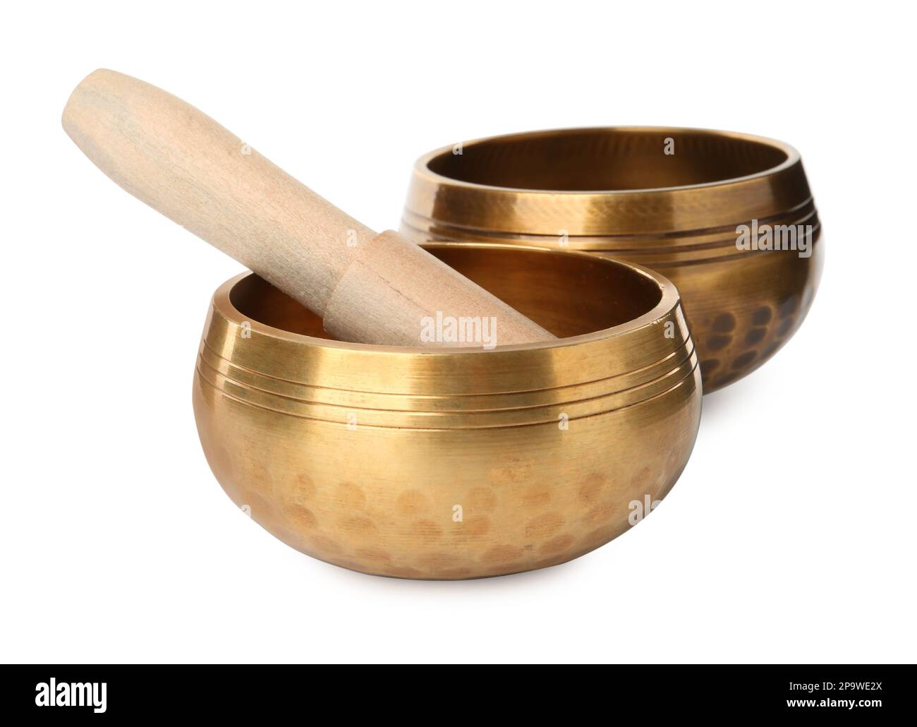 Golden singing bowls with mallet on white background. Sound healing