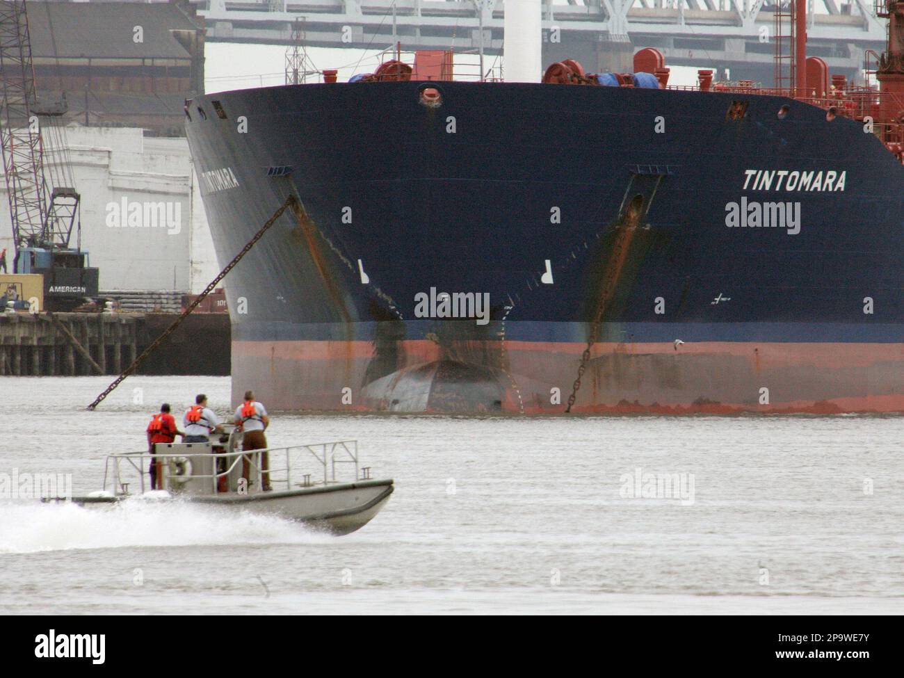 A work boat runs past the tanker Tintomara that is anchored in the ...