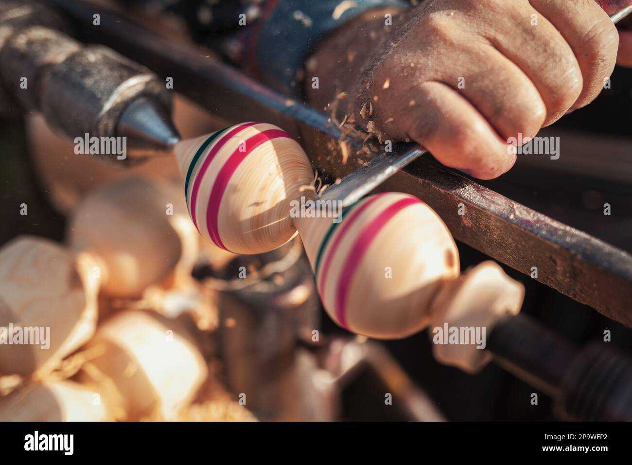 Handmade production stage of spinning top. A woodcarver carving the