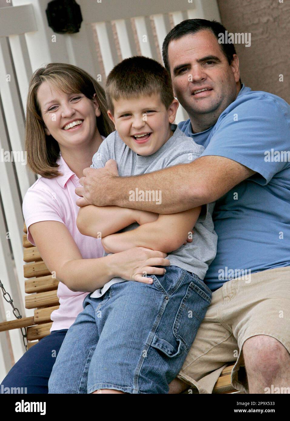Brandon Merrell, 8, center, sits with his mother Amy Merrell, left, and  father Doug Merrell at their home, Friday, July 11, 2008, in Gilbert,  Ariz., The thought of someone without a medical
