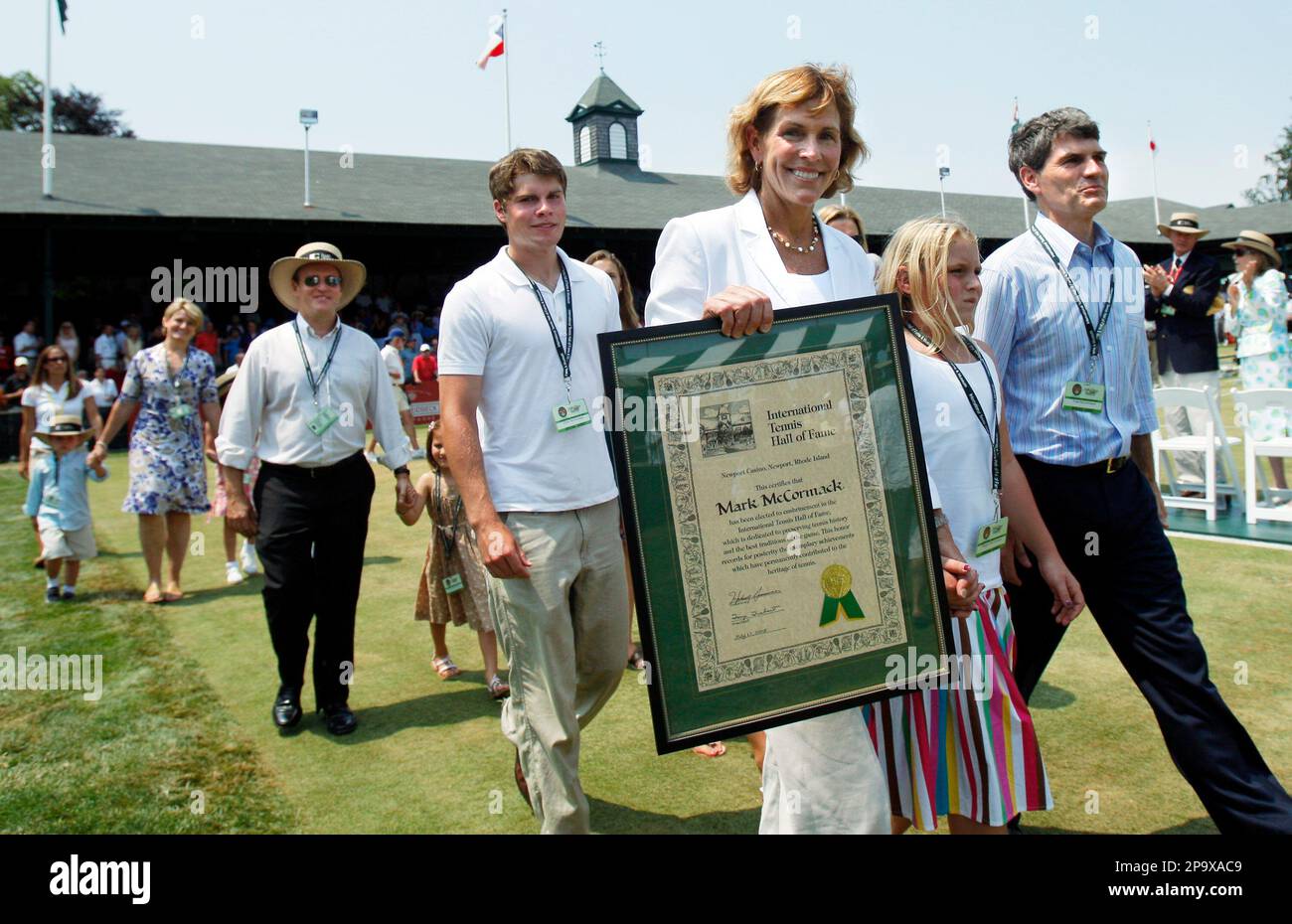 Betsy McCormack, widow of inductee Mark McCormack, the founder and CEO of  International Management Group, holds his plaque as she leads the McCormack  family around center court during his induction posthumously into