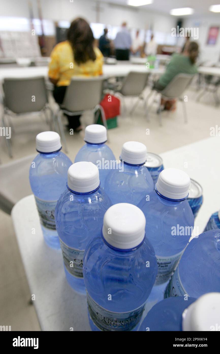 Bottles of donated chilled water sit on a table in the airconditioned